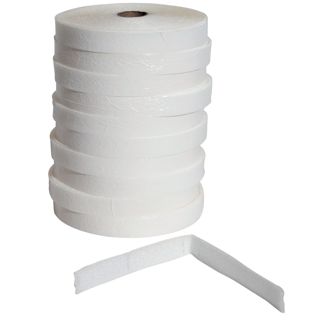 UZIN_Dummy_ES 50_5_2014-02 Een verticaal gestapelde stapel van meerdere witte zelfklevende schuimtape-rollen met een licht gestructureerd oppervlak tegen een witte achtergrond; één schuimstrook ligt vooraan en is in een rechte hoek gebogen, waardoor dikte en poreuze schuimstructuur zichtbaar worden. De rollen hebben een kartonnen kern en een licht glanzende buitenlaag, geschikt voor afdichten, dempen, weerbestendigheid of isolatie.