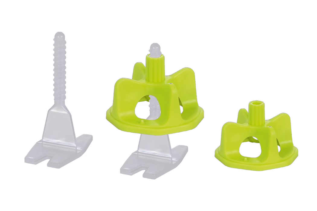 codex_Dummy_LS 2_composing_2020-01 Close-up product photograph of three plastic tile leveling components on a white background: a translucent white spacer with a vertically threaded stem and a slotted base (left), a lime-green plastic cap mounted on a spacer (center), and a separate lime-green cap (right). The pieces are injection-molded plastic with smooth surfaces and an open, cage-like cap design that fits over the spacer stem to align and level ceramic or porcelain tiles during installation. The image is isolated on a plain white background to clearly show shape, texture and functional details.